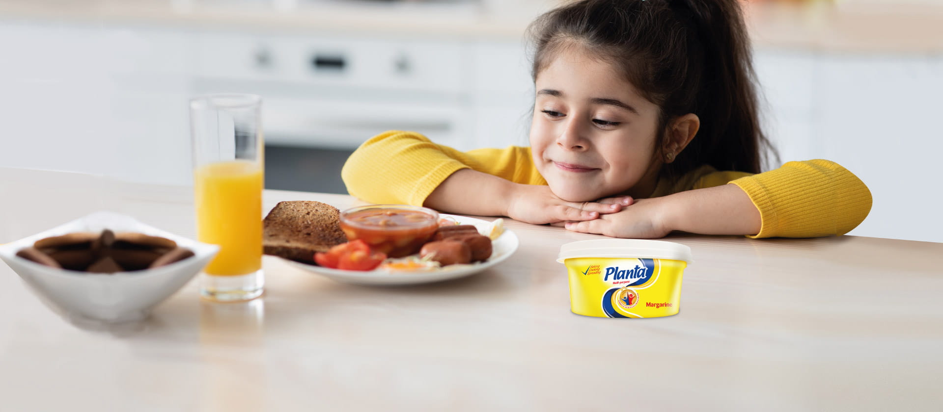 A Malaysian child looking at a dish with Planta product